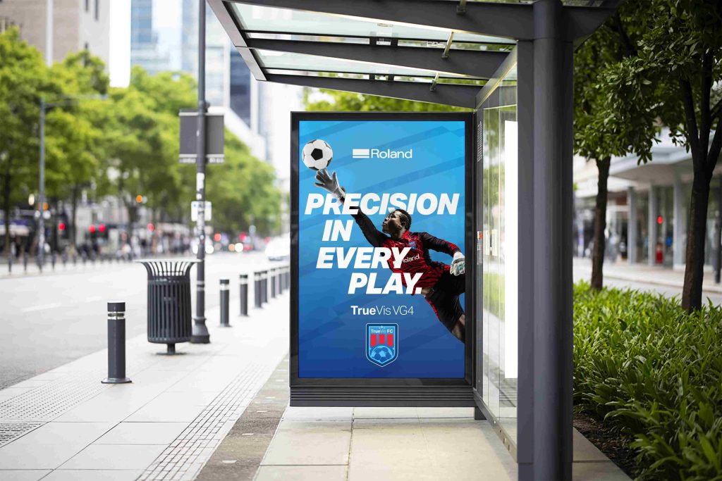 Poster an einer Bushaltestation mit einem Fußballspieler drauf auf blauem Hintergrund. Gedruckt mit der Roland TrueVIS VG4-Serie.