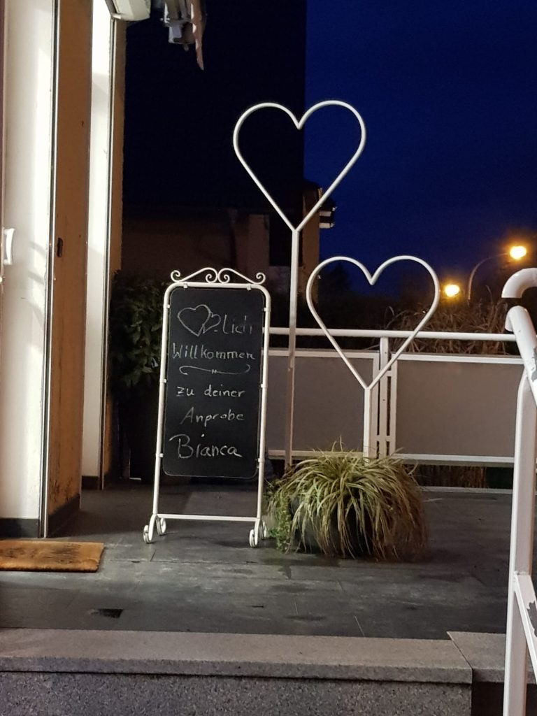 Persönliche Begrüßung auf einer Tafel vor einem Brautmodengeschäft